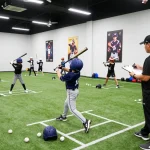 Hitclub baseball training scene with young athletes practicing hitting indoors, energetic atmosphere capturing sports dedication.