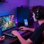 Engaged player tải hitclub app on laptop, highlighting vibrant gaming graphics and modern gaming setup.