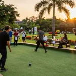 Players enjoying petanque at FOPI Kota Makassar court during sunset, showcasing community spirit and vibrant atmosphere.